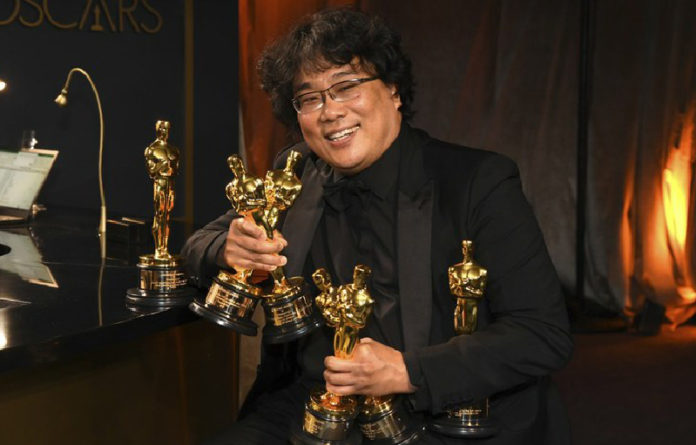 El director Bong Joon-ho posa con las estatuillas del premio Oscar que ganó la cinta 'Parásitos'. Foto Ap / Archivo.