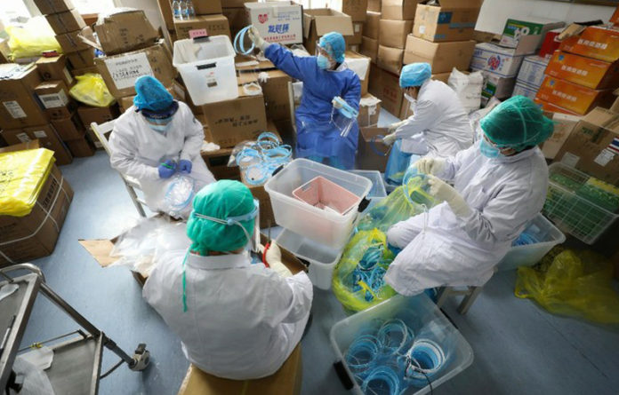 Enfermeras chinas ensamblando mascarillas de protección para uso hospitalario. Foto Ap.