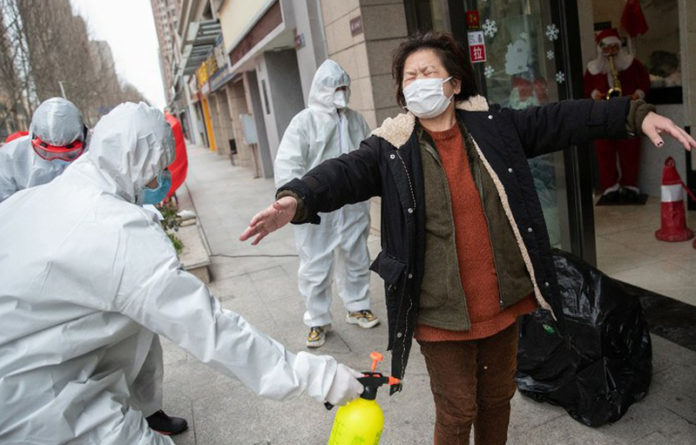 Una mujer dada de alta -tras contraer coronavirus- fue desinfectada antes de ingresar a su vivienda. Foto Afp.