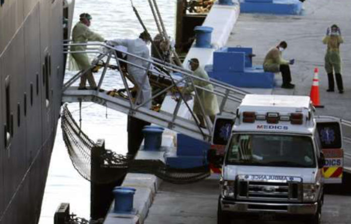 A los pasajeros del crucero Zaandam se les permitió por fin desembarcar en Florida. Uno de los viajeros contagiados es trasladado a un hospital. Foto Ap.