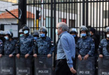 En la imagen, un hombre libanés camina junto a miembros de las fuerzas de seguridad en Beirut. Foto Afp.