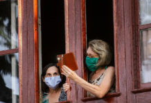 Dos mujeres conversan desde su vivienda en La Habana. Foto Ap.