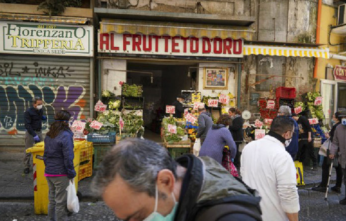 Personas compran frutas y verduras en Nápoles, Italia. Foto Ap.