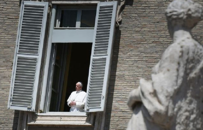 El Papa Francisco observa la Plaza de San Pedro desde el Palacio Apostólico tras ofrecer un mensaje vía remota. Foto Afp.