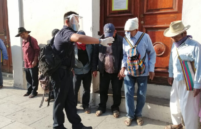 Afuera de las instituciones bancarias de Oaxaca de Juárez, elementos de la Policía Municipal conminan a las personas a cumplir con medidas sanitarias.