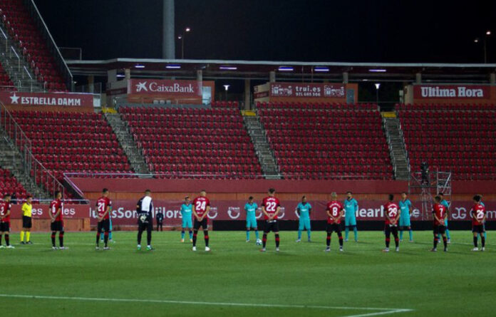 Jugadores del Barcelona y del Mallorca rinden un minuto de silencio por las víctimas del coronavirus previo a su encuentro Foto Afp.