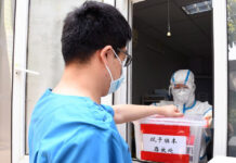 Médico lleva muestras tomadas de pacientes para realizar pruebas de detección de Covid-19 en en el Hospital de Haidian, en Pekin, China. Foto Xinhua.