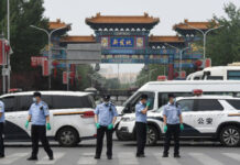 La policía china vigila la entrada al mercado cerrado de Xinfadi en Pekín. Foto Afp.