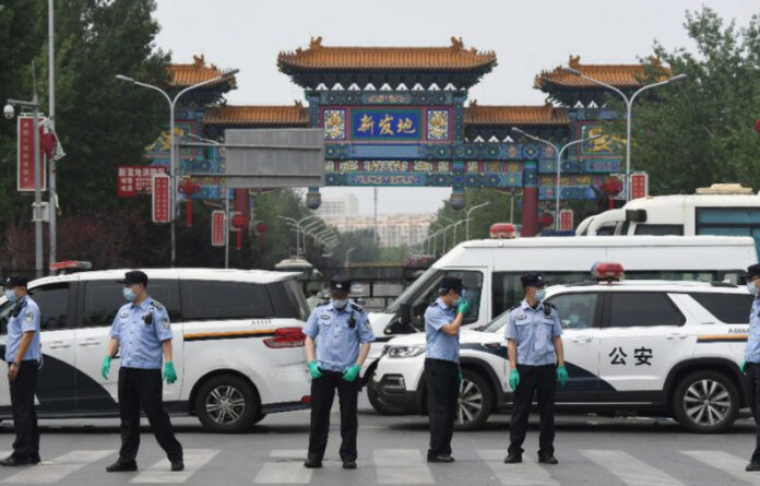 La policía china vigila la entrada al mercado cerrado de Xinfadi en Pekín. Foto Afp.