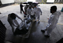 Trabajadores de una funeraria trasladan el cuerpo de una víctima de Covid-19 al crematorio del Panteón San Nicolás Tolentino de Iztapalapa. Foto Ap.