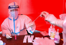 Un trabajador médico recolecta una muestra de una persona para hacer la prueba del coronavirus, en Mudanjiang, China. Foto Afp.