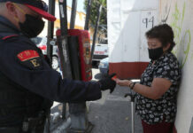 Policía capitalino ofrece gel antibacterial a peatona en la alcaldía Álvaro Obregón. Foto LA JORNADA/José Antonio López.