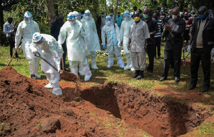 Miembros del equipo de aislamiento del condado de Bungoma entierran el ataúd del doctor Doreen Lugaliki, de 39 años, el primer médico keniano fallecido de Covid-19 en Nairobi, Kenia. Foto Afp.