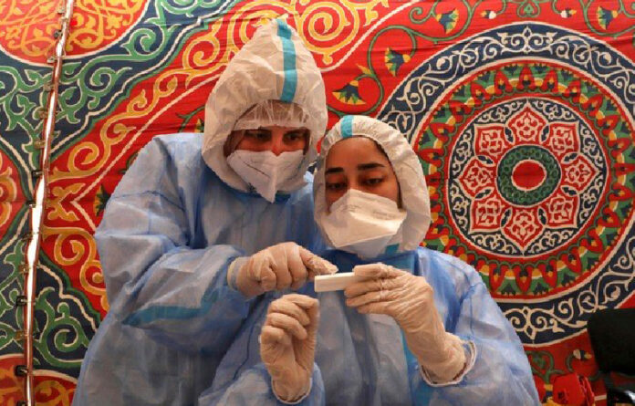 Médicos del Ministerio de Salud palestino toman muestras de sangre de una persona con posible coronavirus en El Hebrón. Foto Afp.