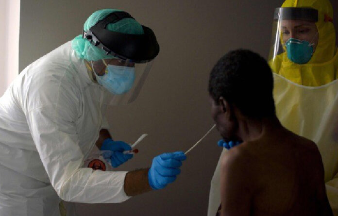 En Texas, EU, un trabajador médico toma muestra de paciente para realizar la prueba de detección de Covid-19. Foto Afp.