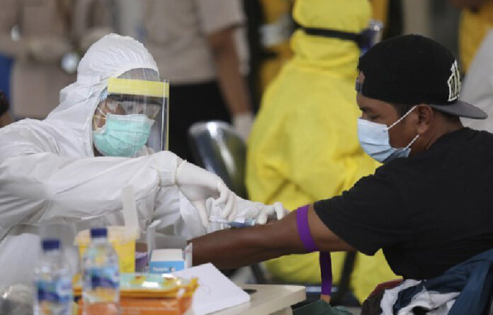 Un trabajador médico obtiene una muestra de un enfermo de Covid recuperado, en Malasia. Foto Ap/ archivo.