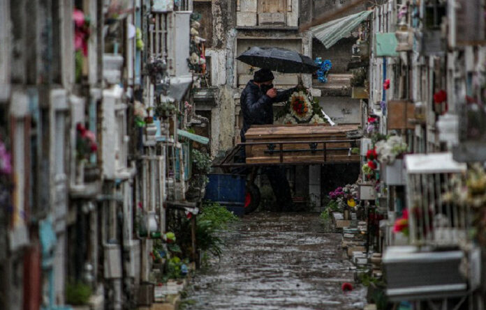 Un hombre despide a un familiar fallecido por sospecha de Covid-19 en el cementerio católico de Bajos de Mena, en el barrio de Puente Alto, en las afueras de Santiago, Chile. Foto Ap.