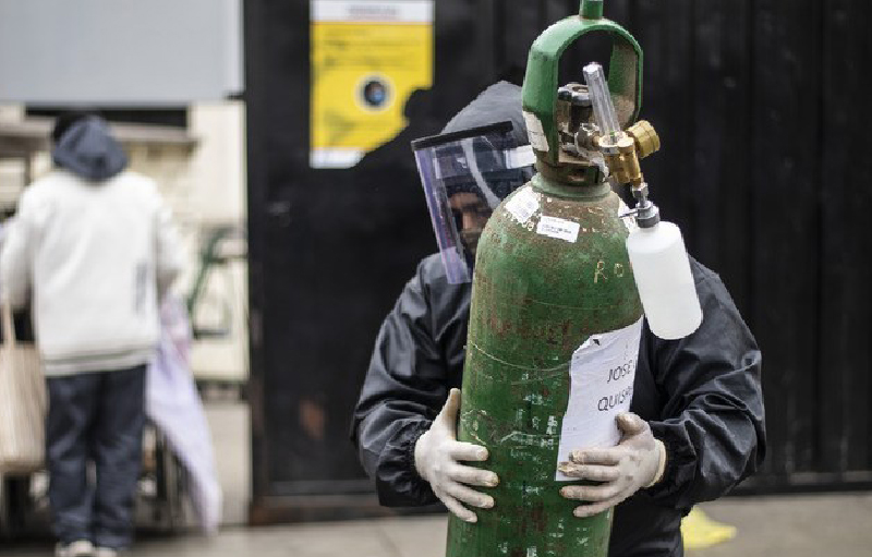 Un hombre carga un tanque de oxígeno vacío para llenarlo para un familiar enfermo con coronavirus, en el Hospital 2 de Mayo de Lima, Perú. Foto Afp.