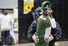 Un hombre carga un tanque de oxígeno vacío para llenarlo para un familiar enfermo con coronavirus, en el Hospital 2 de Mayo de Lima, Perú. Foto Afp.