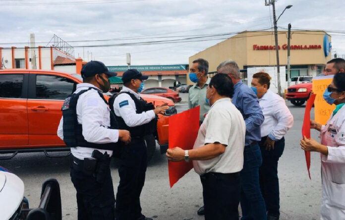 Los policías trataron de disuadir la manifestación de la veintena de integrantes del personal médico, que con pancartas exigían respeto a sus derechos laborales. Foto ‘La Jornada’.