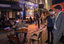 Clientes beben en un ‘pub’ en Londres, Inglaterra, durante el primer día de horario restringido como medida contra la pandemia. Foto Afp.