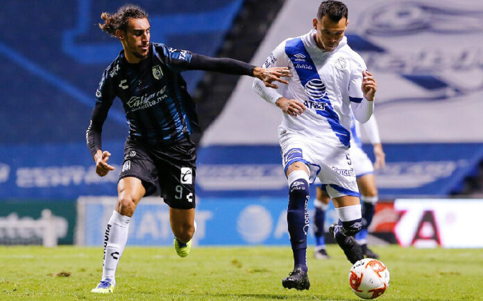 Sebastián Sosa (izq) del Querétaro y el jugador de l Puebla, Daniel Arreola (der) disputan la esférica durante el encuentro. Foto Jam Media.