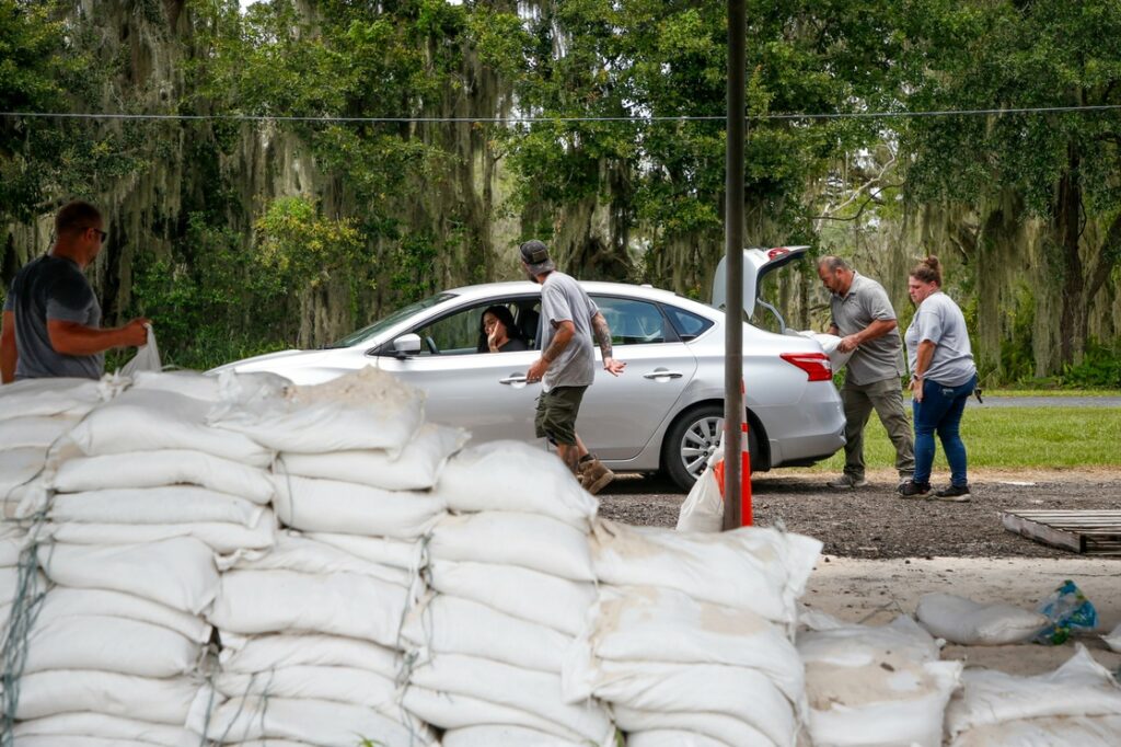 Vigilantes de un parque distribuyen sacos de arena a residentes del condado de Hillsborough, al oeste de la Florida, en preparación de la llegada de la tormenta tropical 'Elsa', el 5 de julio de 2021. Foto Ap.