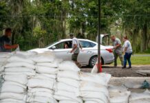 Vigilantes de un parque distribuyen sacos de arena a residentes del condado de Hillsborough, al oeste de la Florida, en preparación de la llegada de la tormenta tropical 'Elsa', el 5 de julio de 2021. Foto Ap.